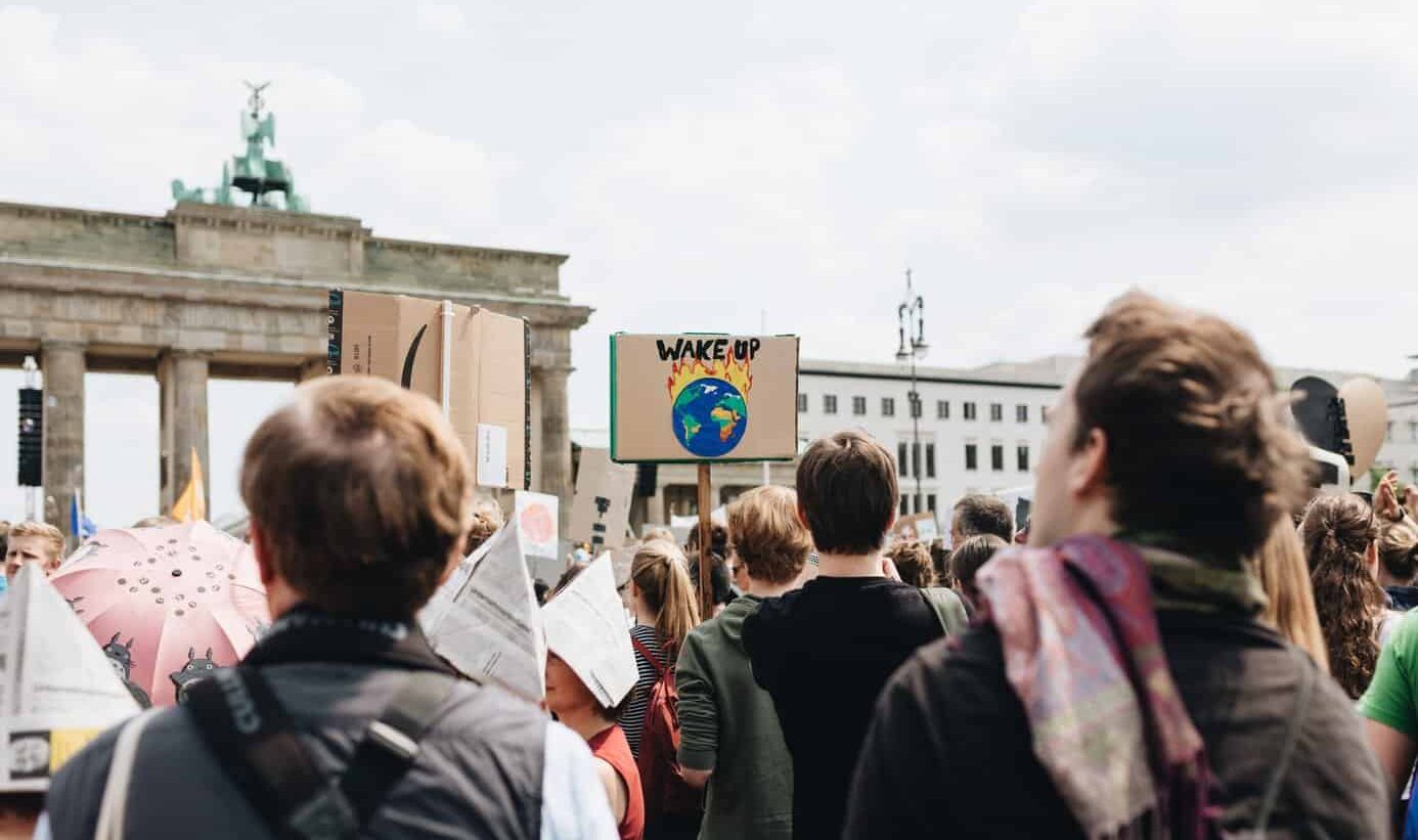 Für Klimaschutz Demonstrierende in Berlin, ein Plakat sticht heraus, auf dem eine brennende Erde zu sehen ist und die Worte "Wake up"